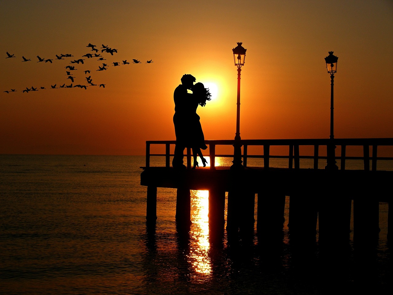 Liebespaar im Sonnenuntergang am Wasser