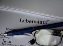 Bewerbungsschreiben mit Stift und Brille