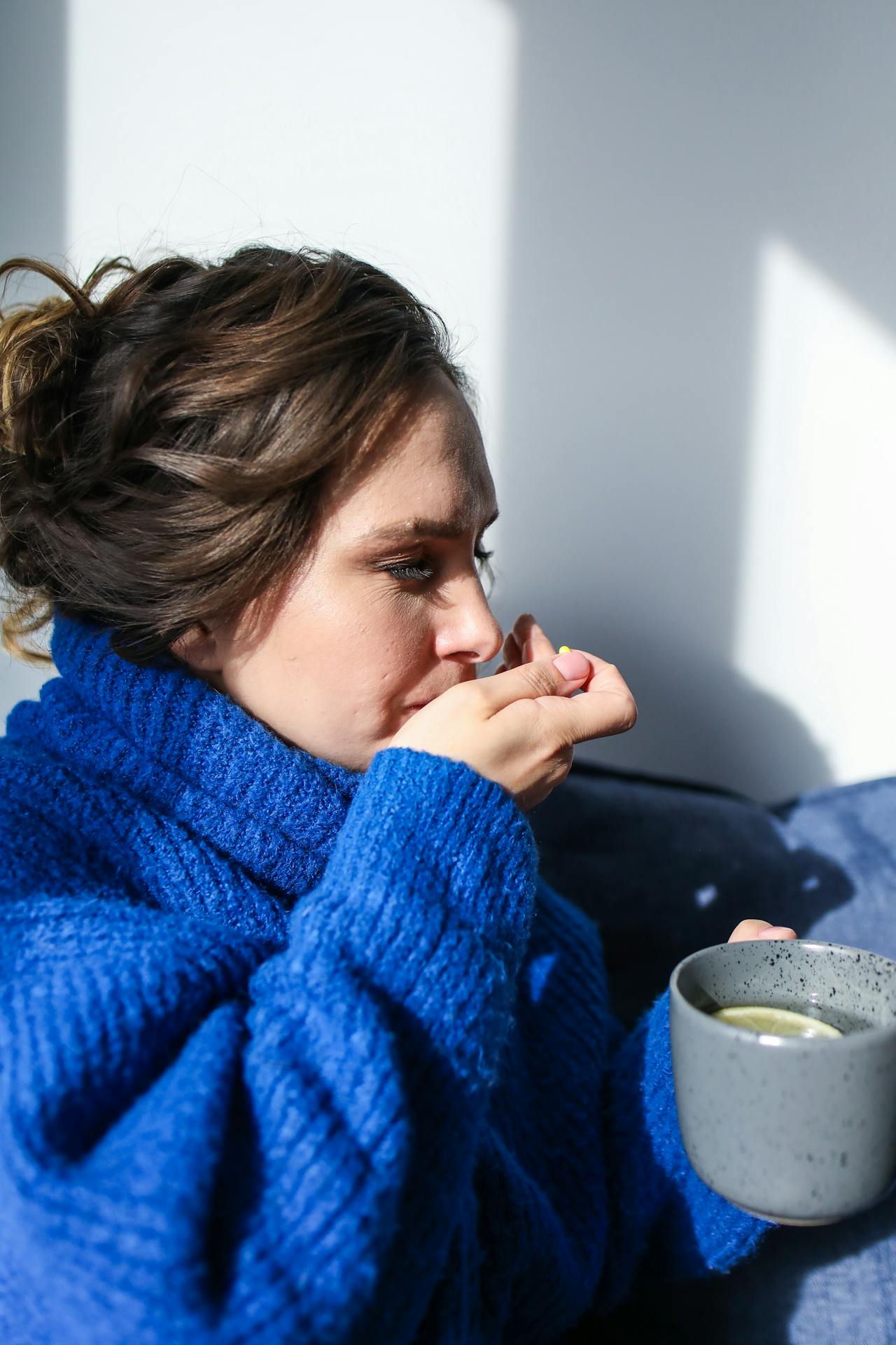 Frau im blauen Pulli ist verschnupft